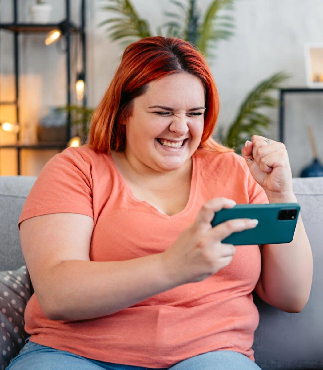 adult woman smiling while tracking glp-1 weight loss progress on smartphone
